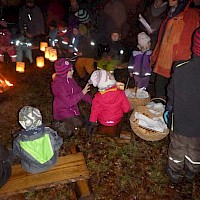 Auf der Wiese am Waldrand wird das Martinsbrot geteilt.